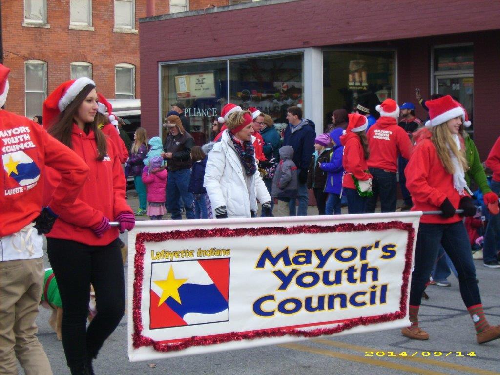 Teens holding a Mayor's Youth Council banner in a parade